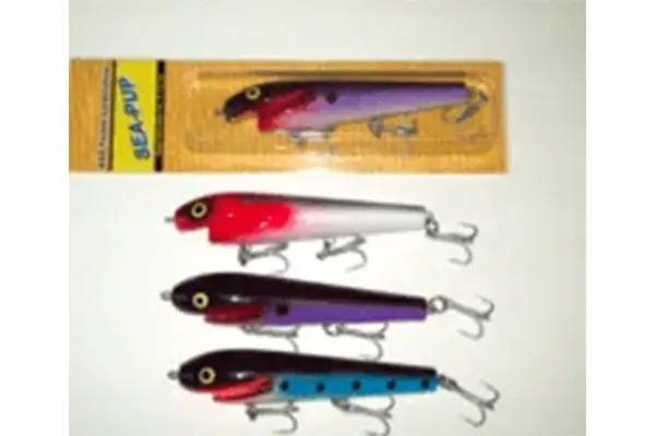 Four fishing lures displayed, with one packaged in a yellow container and three unwrapped beneath it. The unwrapped lures are colored red and white, purple, and blue and black, each with multiple hooks.